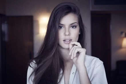 Brazilian actress and model Camila Queiroz poses confidently in a softly lit room, captured in a 4K Ultra HD PC desktop wallpaper and background.
