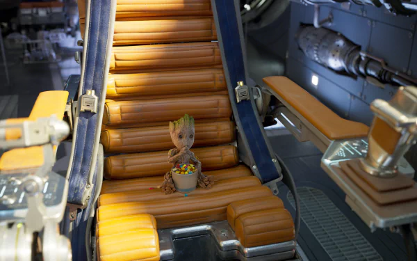HD desktop wallpaper featuring Baby Groot from Guardians of the Galaxy Vol. 2, sitting on an orange cushioned chair in a futuristic setting.