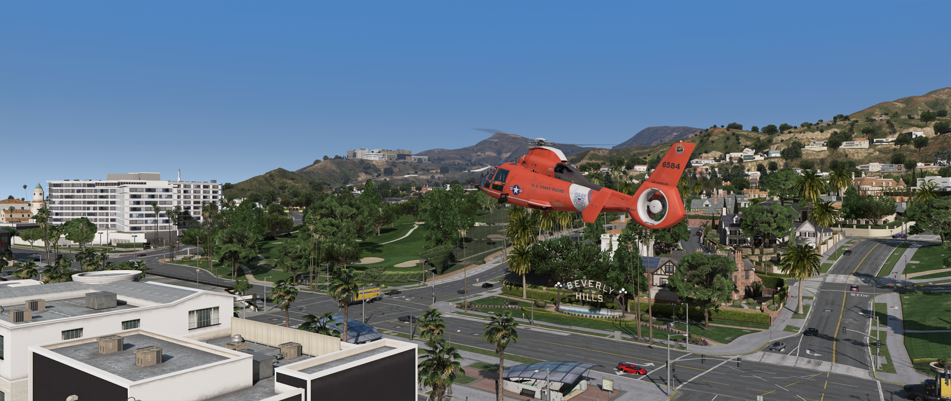 Grand Theft Auto V video game HD PC desktop wallpaper: orange rescue helicopter flies over a palm-lined Los Santos neighborhood with roads, houses and distant hills.