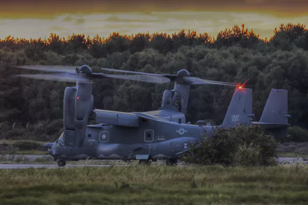 A Bell Boeing V-22 Osprey military aircraft helicopter sits on a grassy field at dusk, captured in 4K Ultra HD quality.