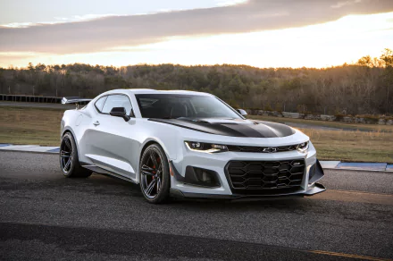 White Chevrolet Camaro ZL1 1LE muscle car parked on asphalt with a natural landscape and sunset sky in the background, captured in high-definition for a desktop wallpaper.