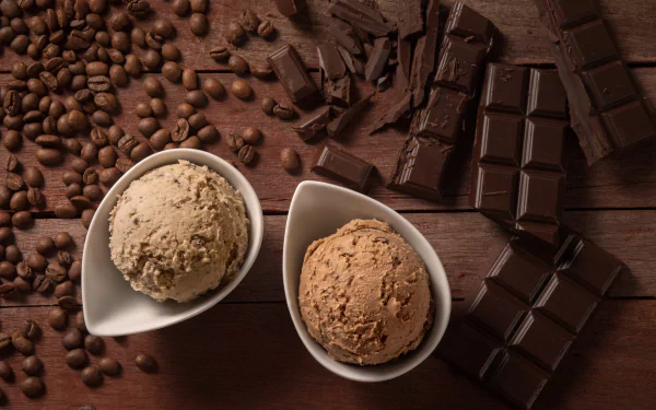 HD desktop wallpaper featuring a still life of coffee beans, chocolate pieces, and two bowls of ice cream, set on a wooden background, highlighting the rich textures and delectable sweets.