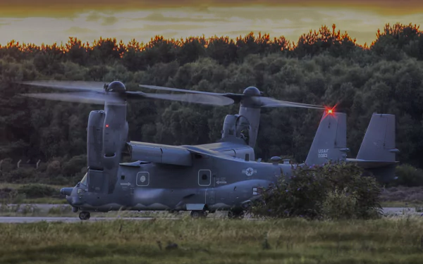 A Bell Boeing V-22 Osprey military aircraft helicopter sits on a grassy field at dusk, captured in 4K Ultra HD quality.