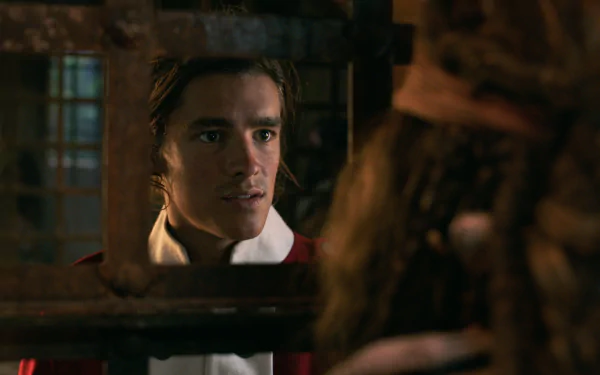 HD PC wallpaper: young man in 18th-century naval coat peers through prison bars at a robed figure, dramatic scene from Pirates of the Caribbean: Dead Men Tell No Tales.