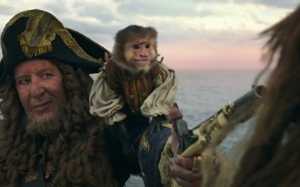 2K desktop wallpaper from Pirates of the Caribbean: Dead Men Tell No Tales showing a grizzled pirate captain with a small monkey on his shoulder against a sunset seascape.