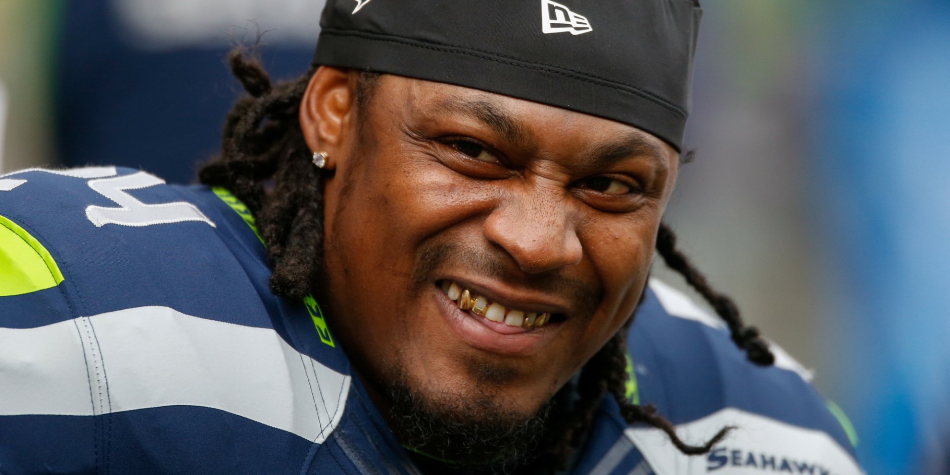 HD desktop wallpaper of Marshawn Lynch in his Seattle Seahawks gear, smiling at the camera.