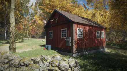 HD PC desktop wallpaper from the video game theHunter: Call of the Wild showing a red hunting cabin by a stone wall amid golden autumn trees and a clear blue sky.