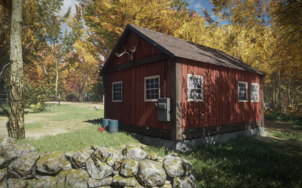 HD PC desktop wallpaper from the video game theHunter: Call of the Wild showing a red hunting cabin by a stone wall amid golden autumn trees and a clear blue sky.
