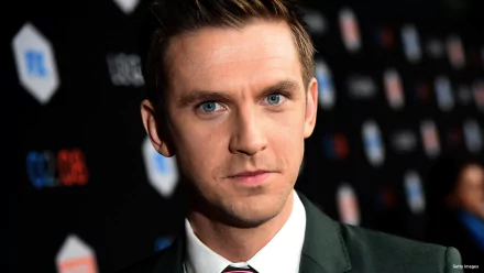 HD desktop wallpaper featuring a sharp, close-up portrait of Dan Stevens in a formal suit with a focused expression.