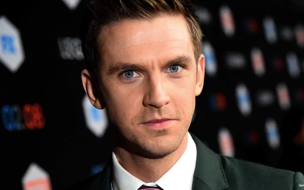 HD desktop wallpaper featuring a sharp, close-up portrait of Dan Stevens in a formal suit with a focused expression.
