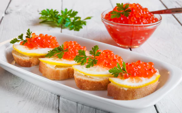 4K Ultra HD desktop wallpaper featuring seafood toast with caviar, garnished with herbs on a white plate and a bowl of bright red caviar in the background.