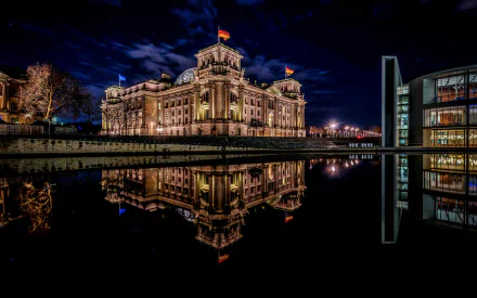 Night view of illuminated Berlin architecture reflected in calm water, showcasing classic and modern man-made buildings in an HD PC desktop wallpaper background.