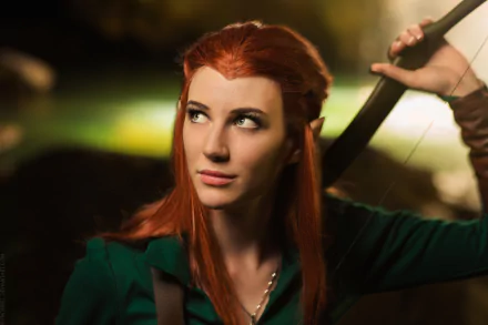 HD desktop wallpaper of a woman cosplaying Tauriel from The Hobbit, featuring red hair and a focused expression while holding a bow.