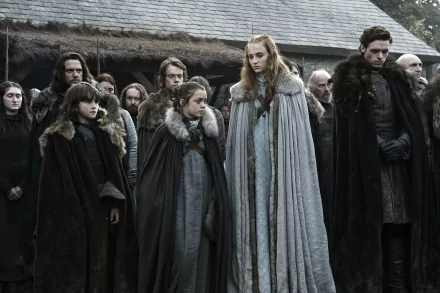 4K Ultra HD PC desktop wallpaper: Game of Thrones—Stark family (Robb, Sansa, Arya, Bran) and Theon Greyjoy standing in winter cloaks outside a wooden hall, solemn and brooding.