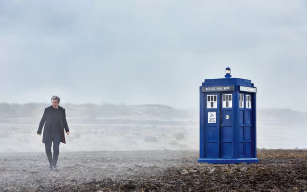 The 12th Doctor, portrayed by Peter Capaldi, walks near the iconic blue TARDIS in a misty landscape, captured in a 4K Ultra HD Doctor Who wallpaper.