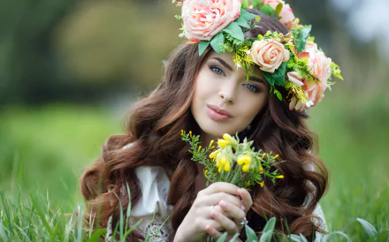 A brunette woman with blue eyes, wearing a flower wreath, holds a small bouquet, set against a blurred, green background in this HD desktop wallpaper and background image.