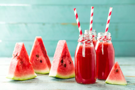 4K Ultra HD wallpaper showing fresh watermelon slices and vibrant red watermelon smoothie drinks in glass bottles with red-and-white striped straws.
