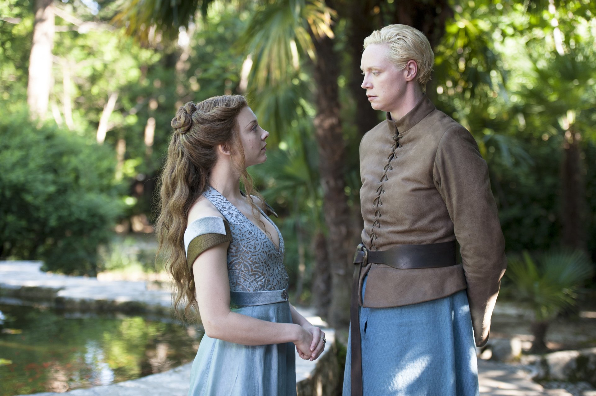 4K Ultra HD PC desktop wallpaper: Margaery Tyrell and Brienne of Tarth from Game of Thrones stand by a sunlit forest pond in period costume, facing each other.