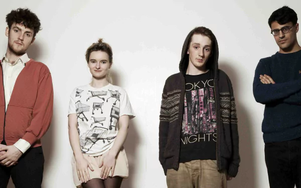 HD desktop wallpaper of Clean Bandit posing for an informal group photo against a light background.