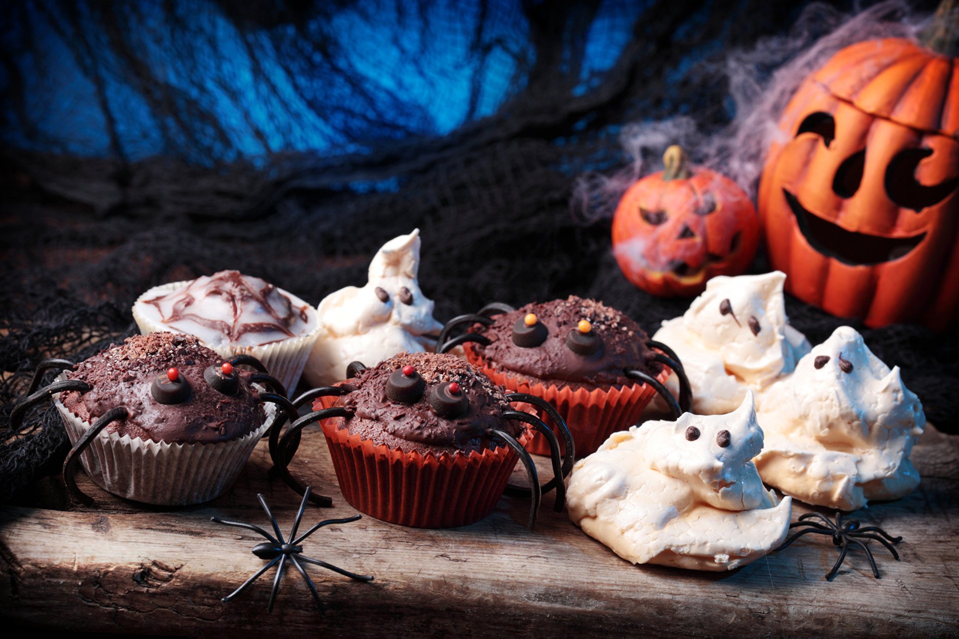 HD PC desktop wallpaper featuring Halloween-themed treats including spider-decorated cupcakes, ghost meringues, and carved pumpkins against a dark, spooky backdrop.