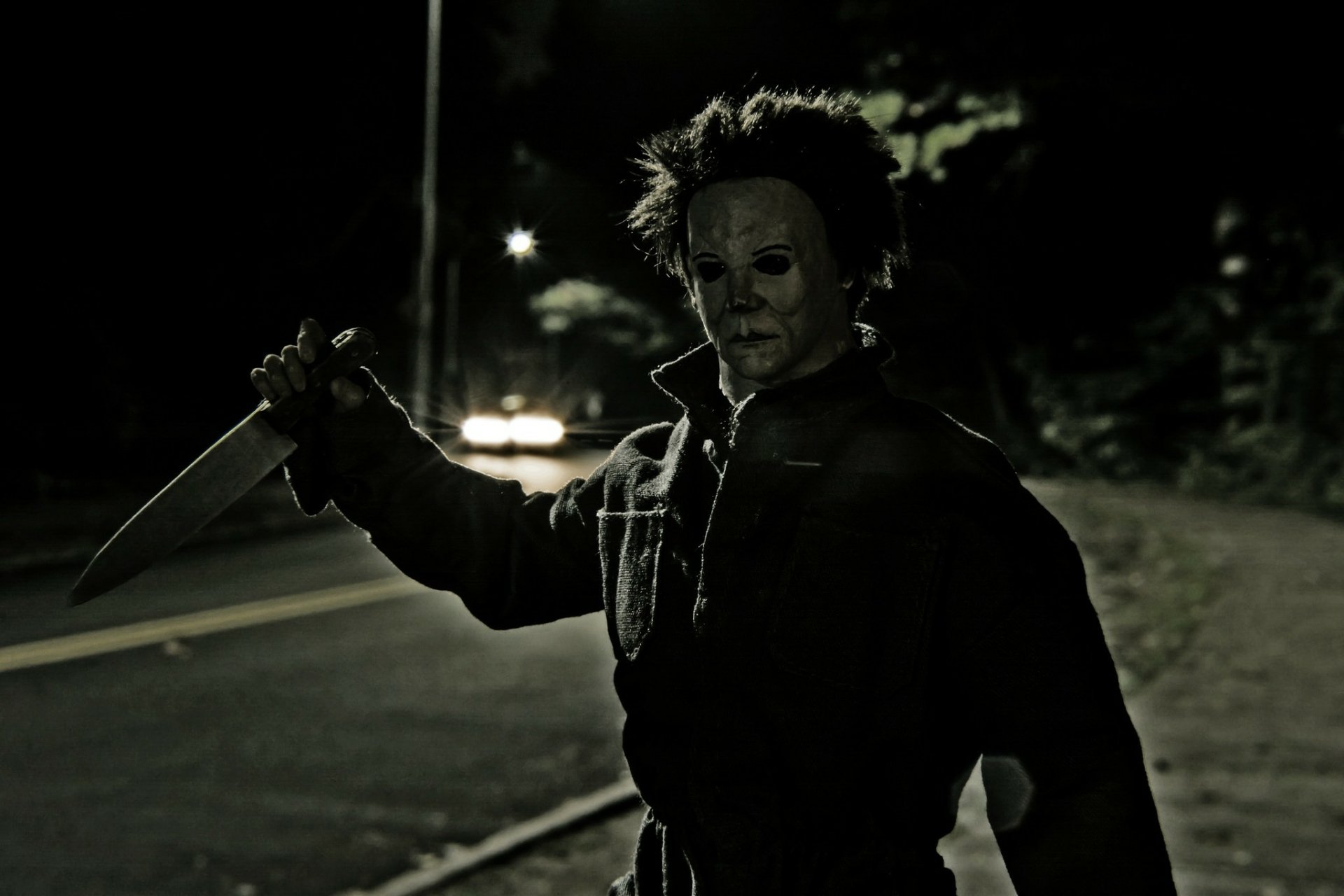 HD PC desktop wallpaper featuring Michael Myers from the 1978 horror movie Halloween, standing on a dark street holding a large knife.