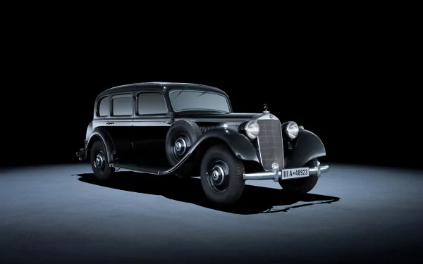 Classic black Mercedes-Benz vehicle centered on a dark studio stage, shot in high definition — PC desktop wallpaper/background.