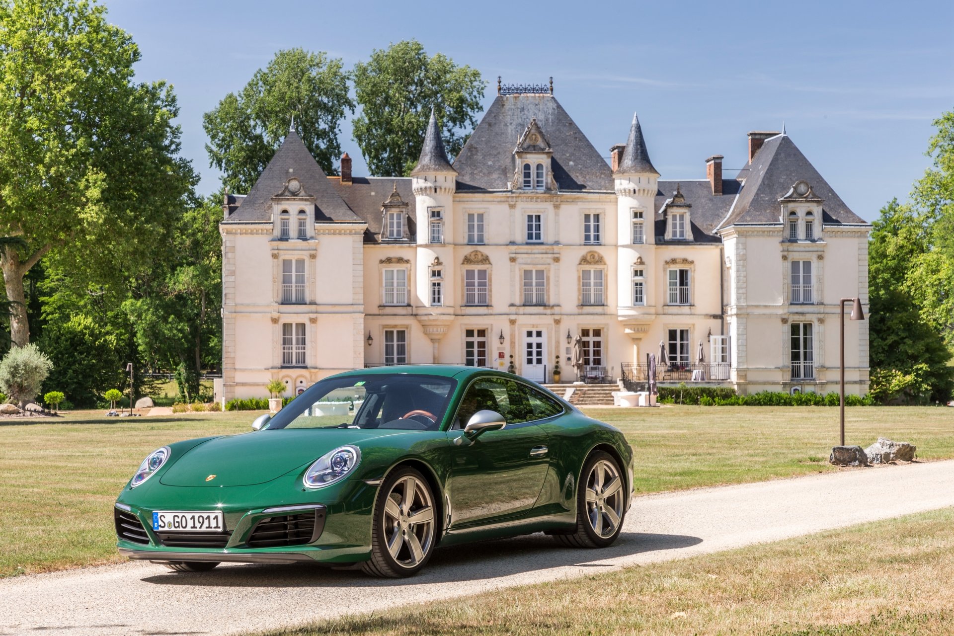A green Porsche 911 Carrera parked in front of an elegant historic mansion, captured in stunning 4K Ultra HD for a PC desktop wallpaper.
