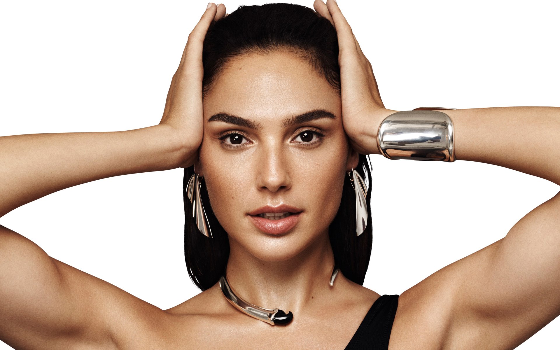 Close-up portrait of Israeli actress and model Gal Gadot with brunette hair, brown eyes, wearing earrings and silver jewelry, shown in high-resolution 4K Ultra HD.