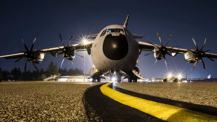 Front view of a military Airbus A400M warplane transport aircraft on a runway at night, featured as an HD PC desktop wallpaper and background.