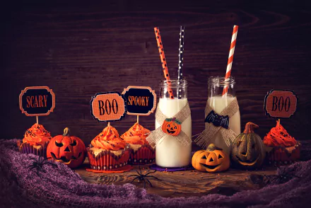 Halloween-themed still life featuring pumpkin cupcakes with festive toppers, two jars of milk with straws, and carved pumpkins on a rustic wooden surface, 4K Ultra HD.