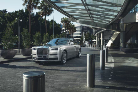 Silver Rolls-Royce Phantom parked under a modern glass canopy, captured in a 4K Ultra HD PC desktop wallpaper and background.