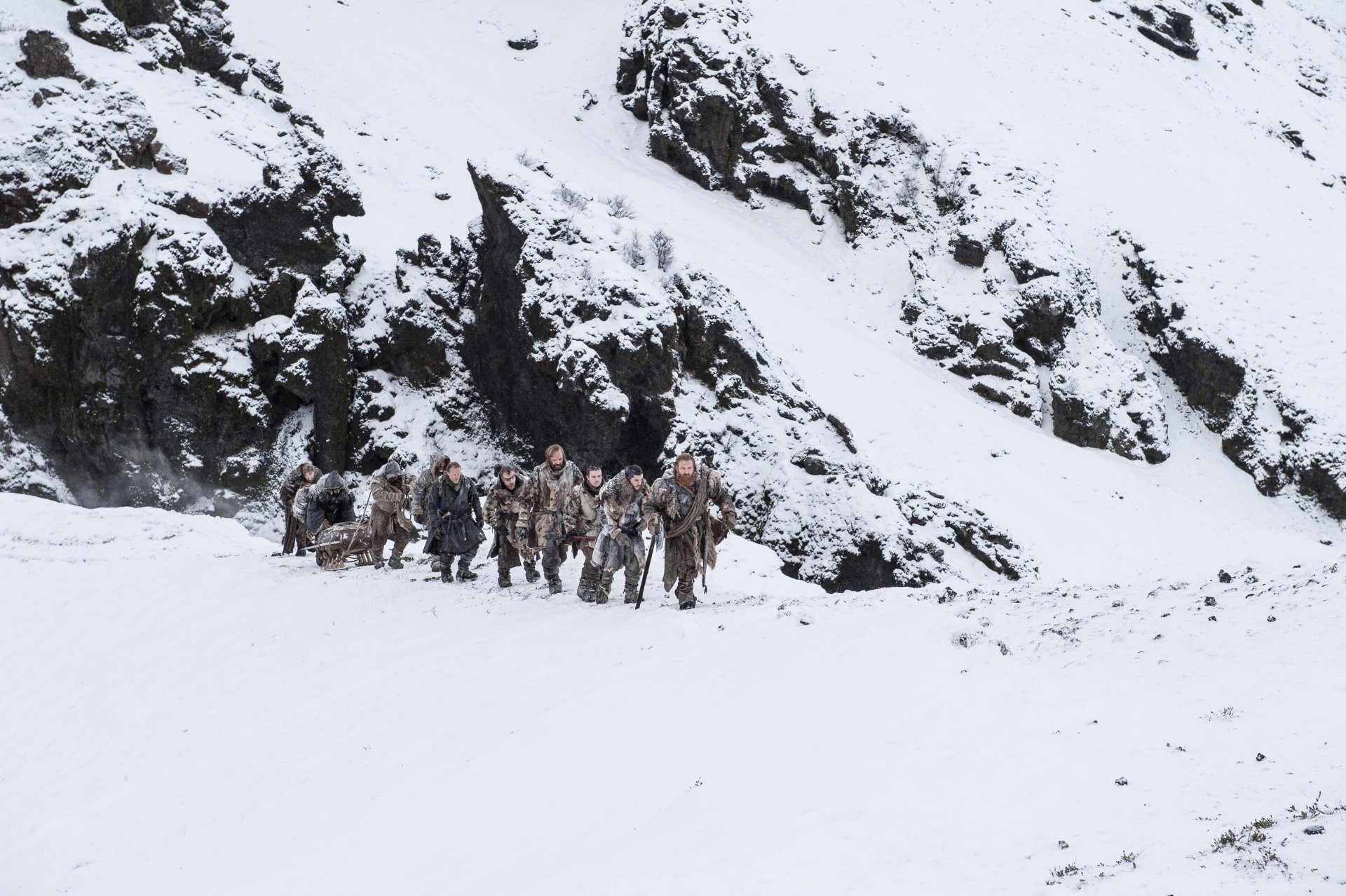 A 4K Ultra HD Game of Thrones wallpaper featuring characters Jon Snow, Tormund Giantsbane, Sandor Clegane, Beric Dondarrion, Jorah Mormont, and Gendry in a snowy landscape.