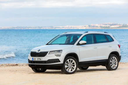 White Skoda Karoq SUV on a sandy beach with a blue sea horizon — HD PC desktop wallpaper background