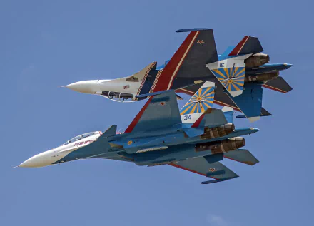 Two Sukhoi Su-30 military jet fighters perform a close formation flight against a clear blue sky, captured in 4K Ultra HD quality.