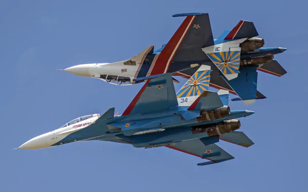 Two Sukhoi Su-30 military jet fighters perform a close formation flight against a clear blue sky, captured in 4K Ultra HD quality.