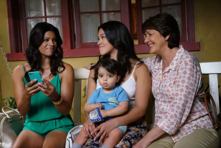 HD wallpaper from Jane the Virgin featuring three generations smiling, including a woman with a toddler on her lap.