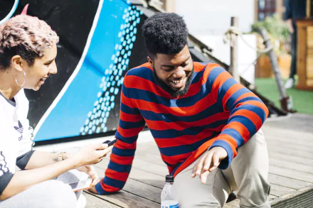 A vibrant HD desktop wallpaper featuring Khalid laughing and enjoying a moment with a friend, reflecting a lively atmosphere infused with music.