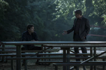 HD desktop wallpaper of a scene from Ozark showing two characters in a tense discussion at a picnic table surrounded by trees.