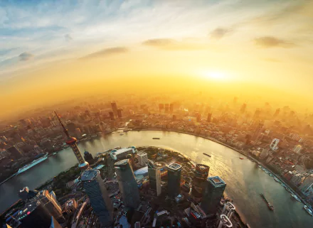 Sunset over Shanghai cityscape with skyscrapers, a cruise ship on the river, and fisheye photography capturing the vibrant urban panorama.