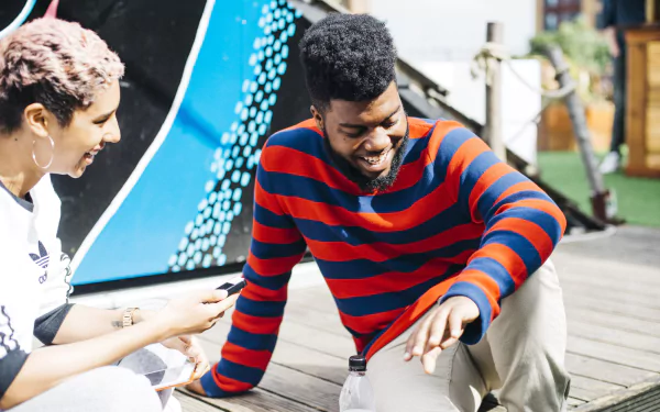 A vibrant HD desktop wallpaper featuring Khalid laughing and enjoying a moment with a friend, reflecting a lively atmosphere infused with music.
