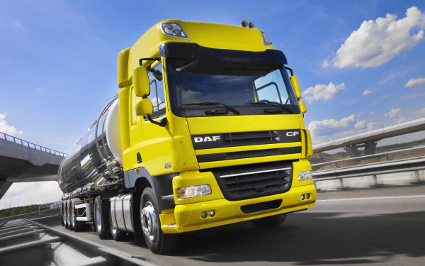 Yellow DAF tanker vehicle on a highway under a bright blue sky — 4K Ultra HD PC desktop wallpaper/background featuring a modern commercial truck.