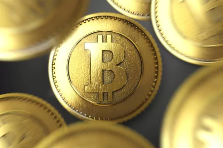 HD wallpaper of golden Bitcoin coins scattered, representing cryptocurrency, with a prominent coin in the center.