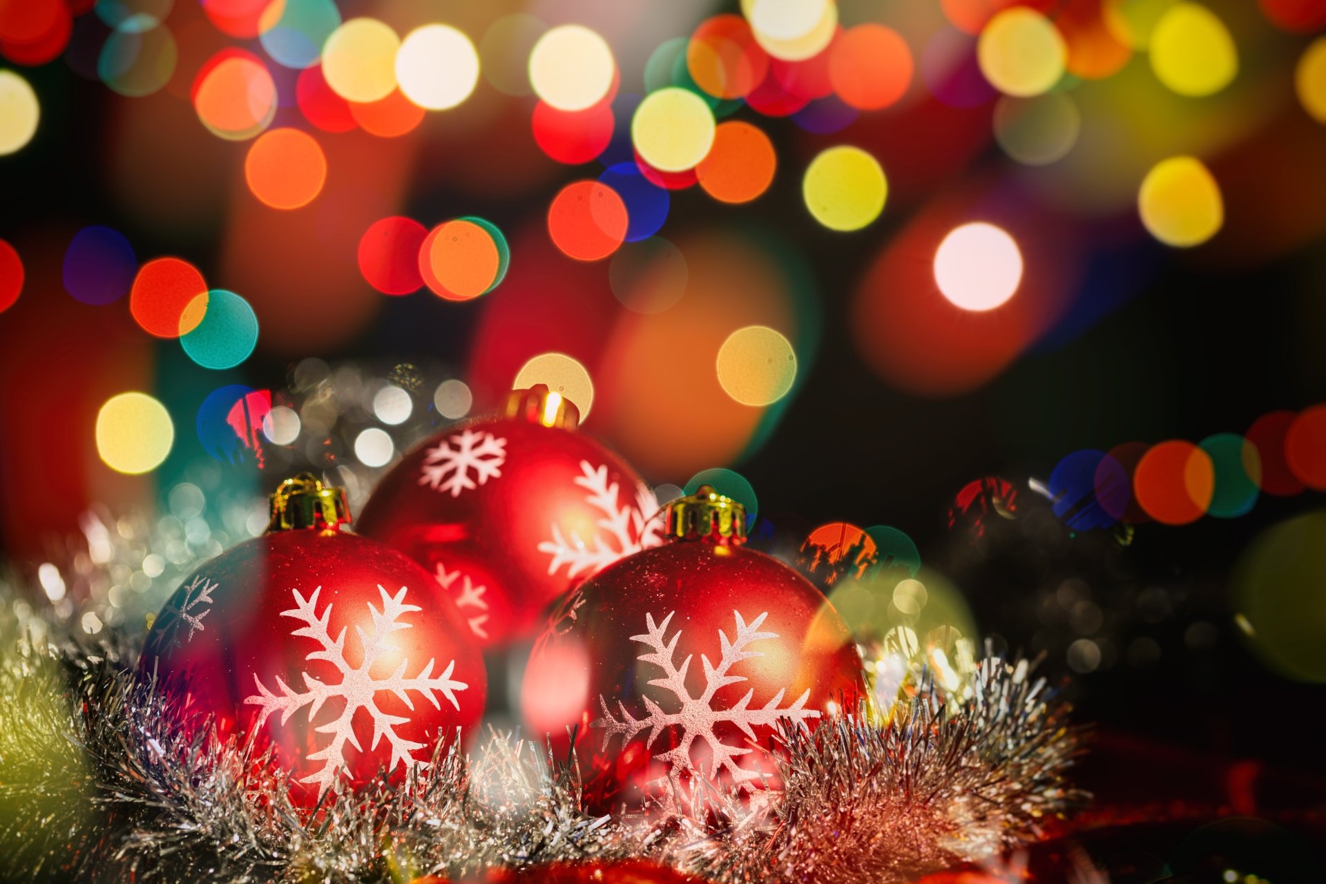 A vibrant 4K Ultra HD desktop wallpaper featuring red Christmas baubles with snowflake designs surrounded by holiday lights and colorful bokeh effects.