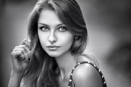 Black and white HD desktop wallpaper featuring a close-up portrait of a female model with captivating eyes and flowing hair.