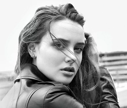 Black and white HD desktop wallpaper featuring a close-up monochrome portrait of actress Katherine Langford with windblown hair and an intense gaze.