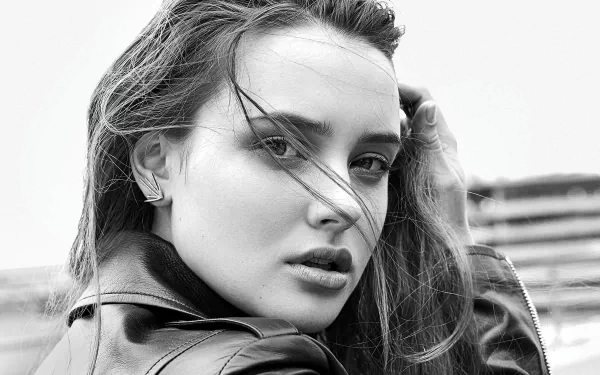 Black and white HD desktop wallpaper featuring a close-up monochrome portrait of actress Katherine Langford with windblown hair and an intense gaze.
