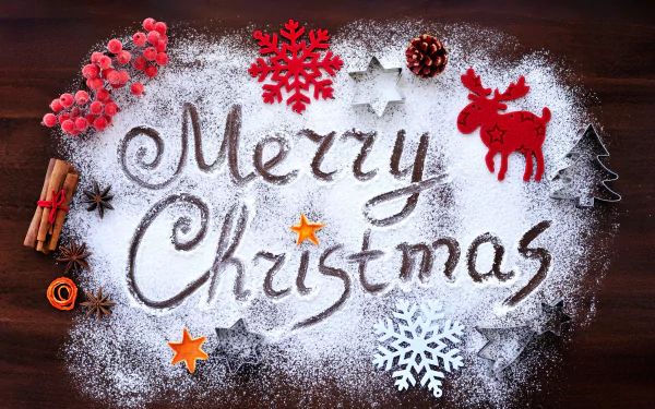 A festive Merry Christmas message written in powdered sugar on a wooden surface, surrounded by holiday decorations like red berries, cinnamon sticks, and snowflakes.