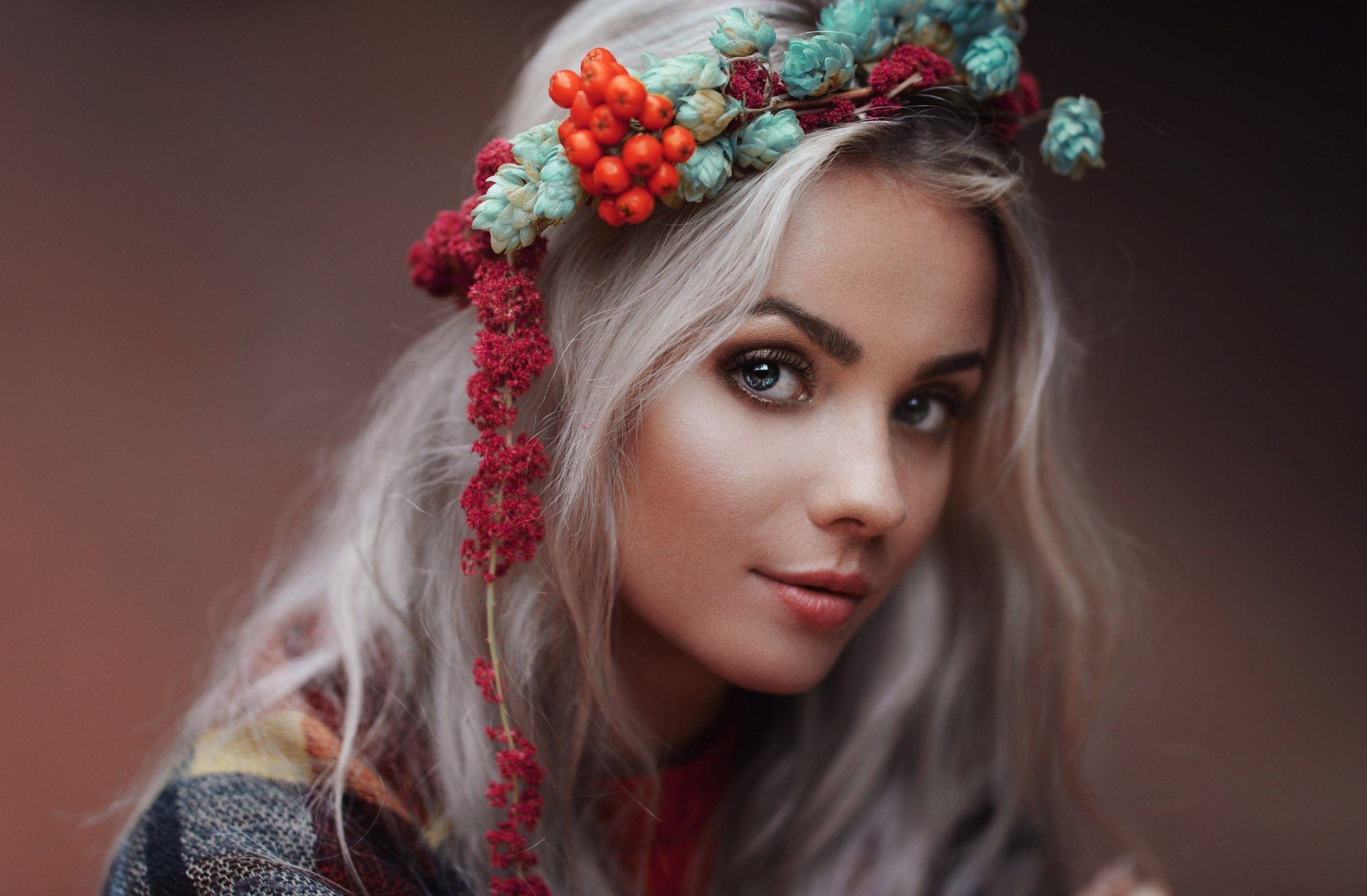 Portrait of a white-haired woman with striking blue eyes wearing a colorful floral wreath, captured in 4K Ultra HD quality as a PC desktop wallpaper.