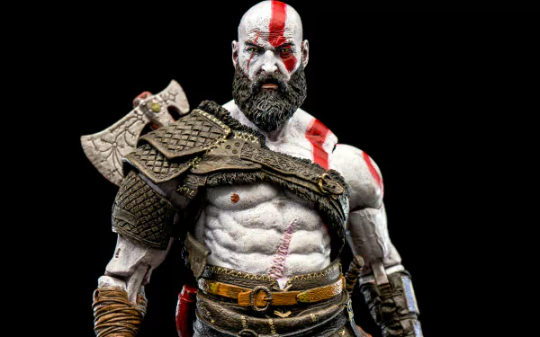 HD desktop wallpaper featuring a detailed figurine of Kratos from the video game God of War (2018), showcasing his muscular build, armor, and red war paint.