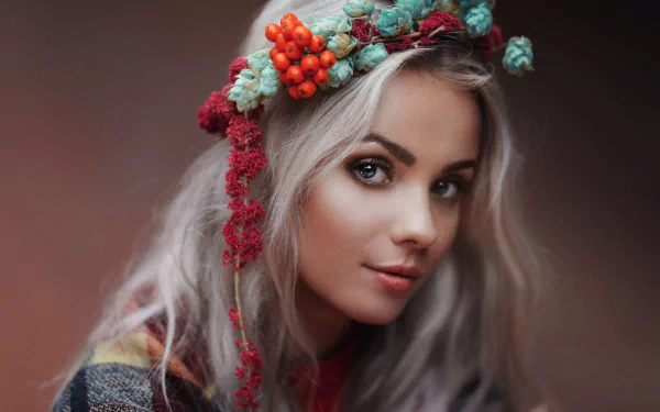 Portrait of a white-haired woman with striking blue eyes wearing a colorful floral wreath, captured in 4K Ultra HD quality as a PC desktop wallpaper.